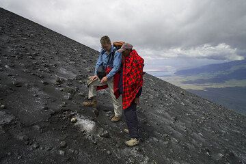 Philip y nuestro guía masai, Peter, examinan uno de los muchos impactos recientes en la ladera sur de la cresta entre el cráter norte y sur. (Photo: Tom Pfeiffer)