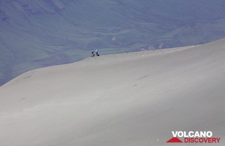 A small group of climbers, perhaps unaware of their dangerous position, have climbed via the old northern route. Note: this route is now extremely dangerous and virtually impassible for descend. In fact, the people on the photo had to descend on the southern route. Minutes after they had passed the crater, explosions started and threw rocks over the path they took.  (Photo: Tom Pfeiffer)