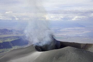 Kurz nachdem die Gruppe den Krater durchquerte, erscheint blaues Gas im Krater und eine Minute danach setzen die ersten schwachen Aschenaustritte ein. (Photo: Tom Pfeiffer)