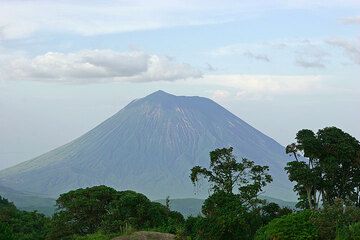 Stratovolcan Ol Doinyo Lengai vu depuis les hauts plateaux du Ngorongoro au cratère Empakai. Le grand hornito dans son cratère actif (sur le côté gauche) apparaît tout juste. (Photo: Tom Pfeiffer)