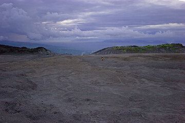 Reinhold im nördlichen Kraterbereich, wo der westliche Overflow liegt. Dort, wo am Boden Dampf aufsteigt, brach im März 2006 der große Lavastrom aus, der duch die Kraterrandlücke im Hintergrund bis zum Fuß des Bergs gerast war. (Photo: Tom Pfeiffer)