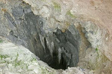 Estalactitas colgando de las paredes de la cavidad. (Photo: Tom Pfeiffer)