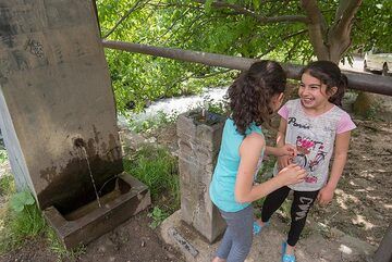 Village girls playing at a fountain. (Photo: Tom Pfeiffer)