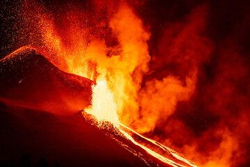 The lava fountain at the lower vent reaches consistently about the same height as the elevation of the summit vents, which eject gas-rich jets: this could be explained by fluid mechanics, where the conduits of both vents are connected and both filled with magma to the rim, but the difference in hydrostatic pressure between the lower and upper pushes the liquid out from the lower vent to reach the same height as it stands in the connected upper vent. This balance seemed to have been be maintained throughout the day and most night. Gasses mainly escape in continuous jets from the upper vents, likely because they managed to separate from the liquid magma at some depth to form an own vertical conduit inside the magma column. (Photo: Tom Pfeiffer)