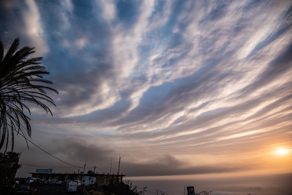 Zurück am Aussichtspunkt El Time ist die Luft sauber und die Farben des Sonnenuntergangs vermischen sich wunderbar mit den kreisförmigen Eruptionswolkenmustern, die noch am Himmel sind. (Photo: Tom Pfeiffer)