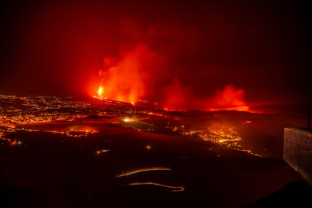 Blick auf das Tal mit Nebelschichten und den Ausbruch vom Aussichtspunkt El Time in der Nacht vom 2. auf den 3. Okt.; Auf der rechten Seite ist der Meereseintritt noch aktiv zu sehen. (Photo: Tom Pfeiffer)