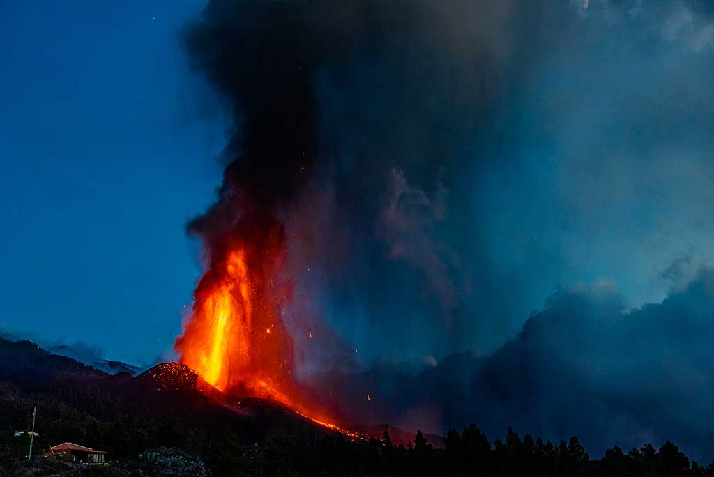 The erupting cone with the lava fountain, ash plume and lava flow at the end of the blue hour. (Photo: Tom Pfeiffer)