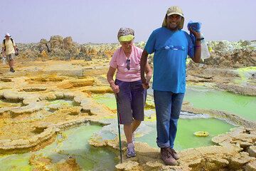 Ecco il gruppo: per primo Solomon, che aiuta Marlies nello stretto sentiero attraverso gli insidiosi stagni salati acidi a Dallol. (Photo: Tom Pfeiffer)