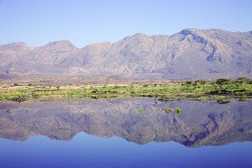 Der Fantalevulkan spiegelt sich im blauen Wasser des Awashsees am Boden des Riftvalleys. (Photo: Tom Pfeiffer)