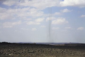 Only 100 m above sea level. A ghostly, tornado-like dust devil greets us on our way through fault-cut lava deserts into the Danakil depression. (Photo: Tom Pfeiffer)