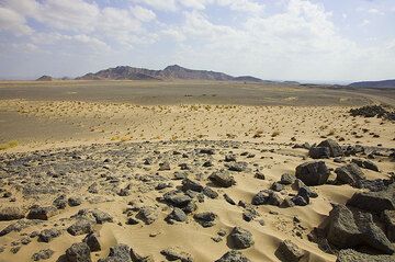 Null Meter ü.N.N. Wir sind zwar noch nicht am Grund der Senke, aber schon längst in der Danakilwüste. Hier hat Wind Sand über die Schotterflächen angehäuft. (Photo: Tom Pfeiffer)