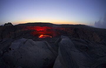 The south pit with the lava lake at dusk and the the steaming north pit in the right of the photo. (Photo: Tom Pfeiffer)