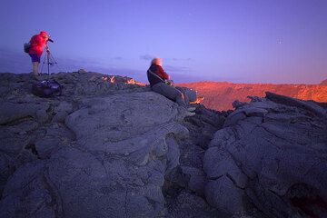 As it grows darker, the lava glow becomes brighter and brighter and its light makes Frank's red jacket (yes, it was a bit chilly up there!) shine even more. Karinna is still on her spot.  (Photo: Tom Pfeiffer)