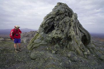Franz standing next to the large hornito on the northern caldera rim where an eruption in the 1990s overflowed the north crater and the caldera. (Photo: Tom Pfeiffer)