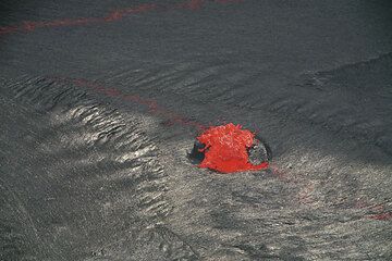 A small fountain starts by disrupting the crust along a weak rift on the thin crust of the lava lake. (Photo: Tom Pfeiffer)