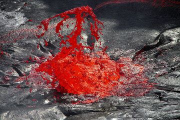 Das entweichende Gas vom Lavasee erzeugt brodelnde Magmablasen, die an der Oberfläche zerplatzen. Dabei wird die flüssige Lava in dünne Häute und feine Fäden zerrissen, die man auch Peles Haar nennt.  (Photo: Tom Pfeiffer)