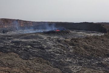 A first view of the south crater on 25 Nov 2010, from the western caldera wall. The crater is largely filled with overflows from the lava lake, and the lower northern rim of the crater has diappeared under overflows. (Photo: Tom Pfeiffer)