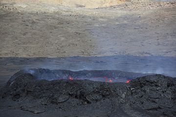 View of the lava lake standing relatively low inside the ring wall. Another group in the background on the caldera wall. (Photo: Tom Pfeiffer)