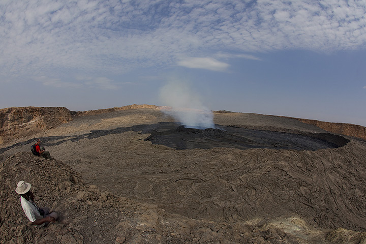 Kwame and Michel watching the lava lake from a vantage point on a little hill. (Photo: Tom Pfeiffer)