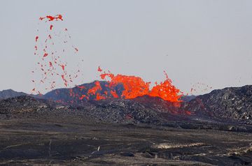 Parfois, des grandes quantités de lave sont projetées à l'extérieur du rempart créant des petites coulées secondaires. Le déchirement de bulles de lave, déchiquète des lambeaux qui sont étirés et effilés par le flux gazeux en de minces fils de lave, les cheveux de Pélé. (Photo: Tom Pfeiffer)