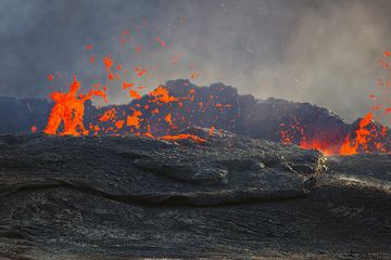 The lake has risen and the impressive lava fountains seen from the same height as the lava lake's surface. The heat blurs the air above the lake. (Photo: Tom Pfeiffer)