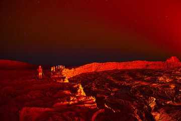 The illuminated crater wall of the south crater. A group of tourists stands on the rim and watches the activity in the lava lake... (Photo: Tom Pfeiffer)