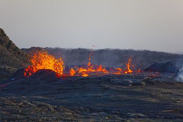 In the afternoon of 26 Nov, the lava level often rises to the very rim, but the walls still hold and after each high-magma level episode, the lava drops again a few meters. (Photo: Tom Pfeiffer)