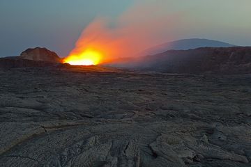 Soirée sur la caldeira du volcan Erta Ale. La lueur de la lave devient extrêmement brillante. Un seul observateur se tient toujours près du lac de lave et ne représente qu’un tout petit point sur l’image. (Photo: Tom Pfeiffer)