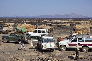 Landcruisers gather at the basecamp of Erta Ale. The volcanic chain to the north in the background, including Alu and Dalafilla volcanoes. (Photo: Tom Pfeiffer)