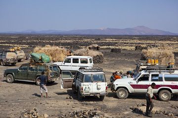 Landcruiser versammeln sich im Basislager von Erta Ale. Die Vulkankette im Norden im Hintergrund, einschließlich der Vulkane Alu und Dalafilla. (Photo: Tom Pfeiffer)