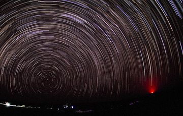 Nuit sans lune sur le désert de Danakil en regardant vers le nord en direction de Polaris, au-dessus de l'horizon. La lueur du lointain volcan Erta Ale est visible à droite. (Photo: Tom Pfeiffer)