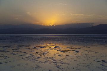 Sonnenuntergang mit der Silhouette der entfernten Berge im Salzsee gespiegelt (Photo: Tom Pfeiffer)