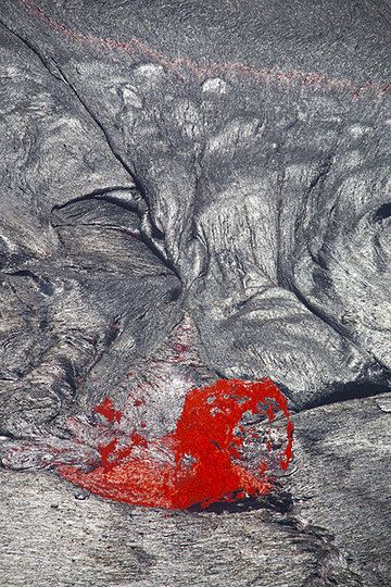 A lava fountain casts its shadow onto the silvery crust of the lava lake. (Photo: Tom Pfeiffer)