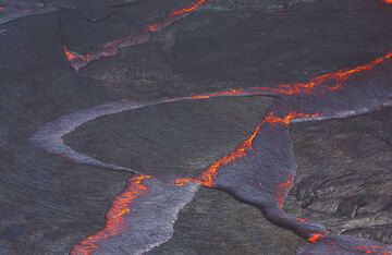 Schwimmende Stücke kaum erstarrter, dunkler Lavakruste, die den aktiven Lavasee von Erta Ale bedecken, bilden Riss- und Subduktionsmuster, die die Plattentektonik der Erde im Miniaturformat veranschaulichen. (Photo: Tom Pfeiffer)