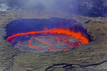 After an extended period of stable crust and relative inactivity, the now heavy crust starts to overturn and sink back into the liquid lake, causing very violent fountaining all along the perimeter of the lake and new rapid rifts creating new crust.  (Photo: Tom Pfeiffer)