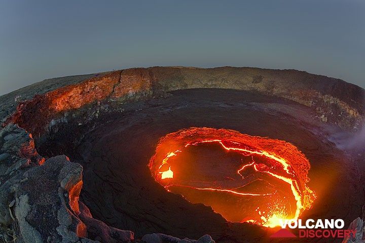 Der Lavaauswurf erleuchtet den inneren Krater. Einige Beobachter sind auf dem linken und gegenüberliegenden Kraterrand. (Photo: Tom Pfeiffer)