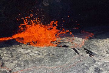 "Lava fountains" are near-continuous gas bubbles escaping from the lava lake: they are the motor of the lake, transporting heat energy from the magma chamber to the surface and keeping the lake - underneath a thin, slvery crust - liquid and boiling where the gasses escape. (Photo: Tom Pfeiffer)