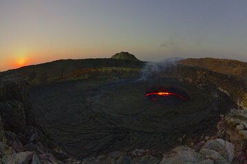 The sun is just about to rise above the horizon. The lava lake is mostly crusted over and the dry weather makes for a very clear view onto the lake. (Photo: Tom Pfeiffer)