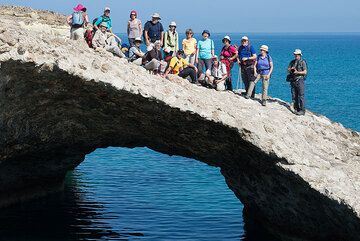 Group photo on a natural sea arc, sculptured by the waves into the spectacular pumice breccia deposit near Papafragkos. (Photo: Tom Pfeiffer)