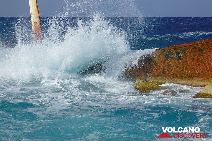 Eine mächtige Welle schlägt über das Schiffswrack (Photo: Tom Pfeiffer)