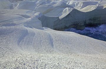Weich geschwungene Kurven in der Oberfläche der weißen Bimssteinklippen vei Sarakiniko (Photo: Tom Pfeiffer)