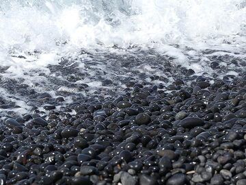 Vagues déferlant sur la plage de galets noirs de Hohlaki (Photo: Ingrid Smet)