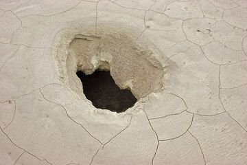 Hole containing boiling water in the mud crust covering the Stefanos crater floor (c)