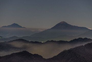 View towards the western part of Guatemala's volcanic front with the silhouettes of Tacana (left background), at the border with Mexico, and Tacomulco volcano (right), where a light from a mountain camp is visible. (Photo: Tom Pfeiffer)