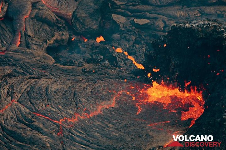 Pieces of lava are flying from the vent in a parabola above the lava lake. (Photo: Tom Pfeiffer)