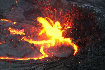 Lava spattering from a vent feeding a lava lake in Kilauea's Pu'u 'O'o crater.  hawaii_e7170.jpg (Photo: Tom Pfeiffer)