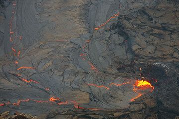 The spattering vent feeding the lava lake and zig-zag fractures on the surface. (Photo: Tom Pfeiffer)