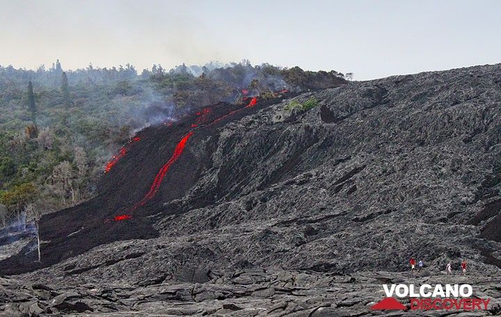 A tour group departs the leading edge of an 'a'a lava flow at the base of Pulama Pali, being fed from the Peace Day Fissure on Pu'u 'O'o vent on K?lauea volcano on December 4, 2011. (Photo: Philip Ong)