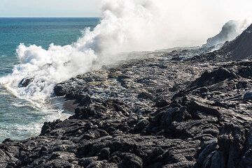 Within only 2 months, a significant, approx. 50 m wide bench of new land has been created. The feeding lava tube is located beneath the area with the bluish fumes in the right background at the older cliff. (Photo: Tom Pfeiffer)