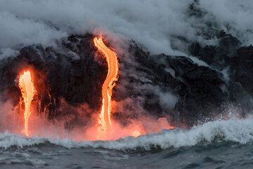 Two active lava flows pouring into the sea just seconds before another wave hits them. (Photo: Tom Pfeiffer)